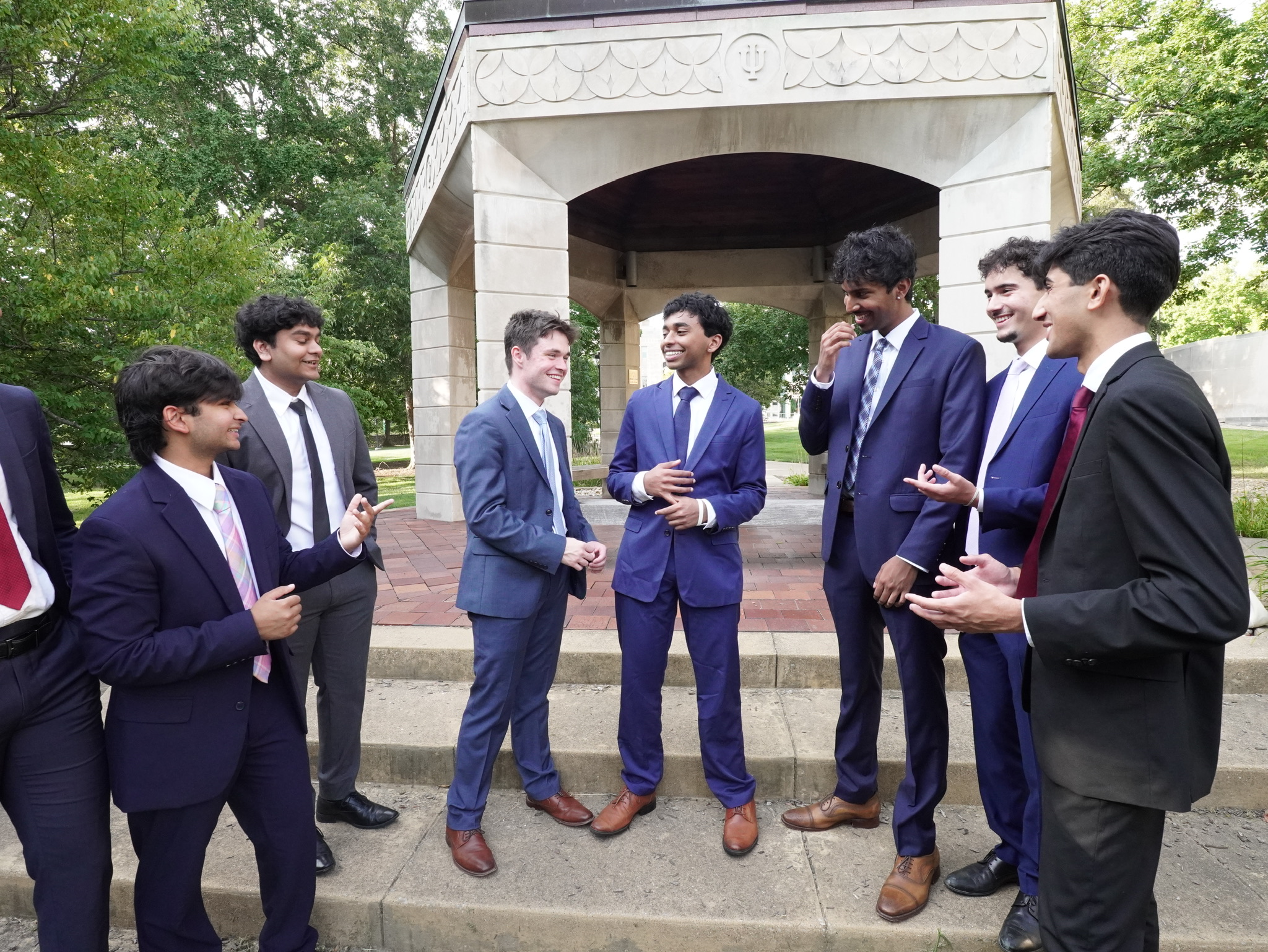 812 Consulting members in conversation outside on campus